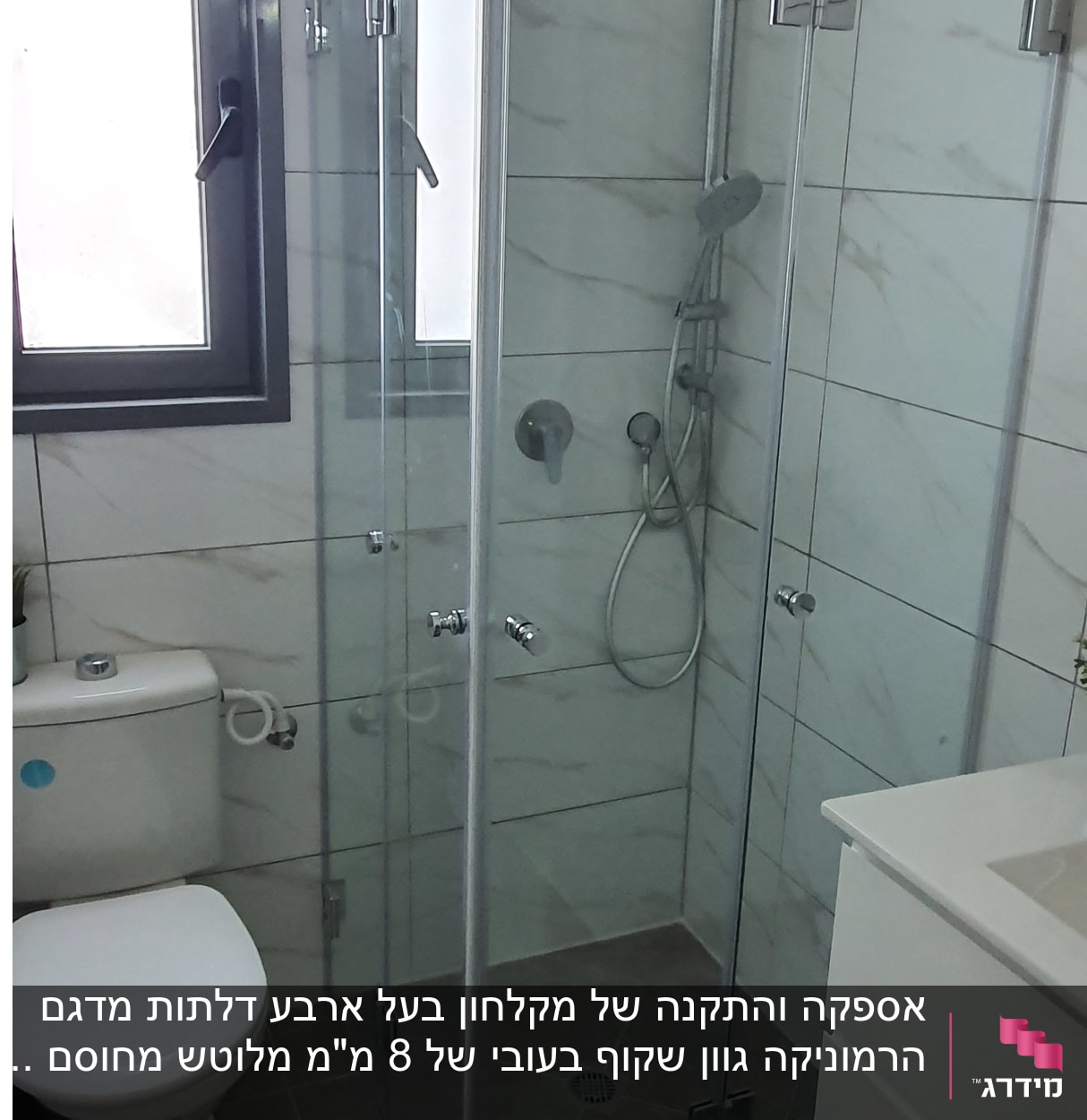 מקלחון זכוכית עם ראש מקלחת וכיור לידו
